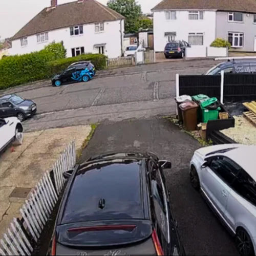 Wide security camera view of a residential driveway